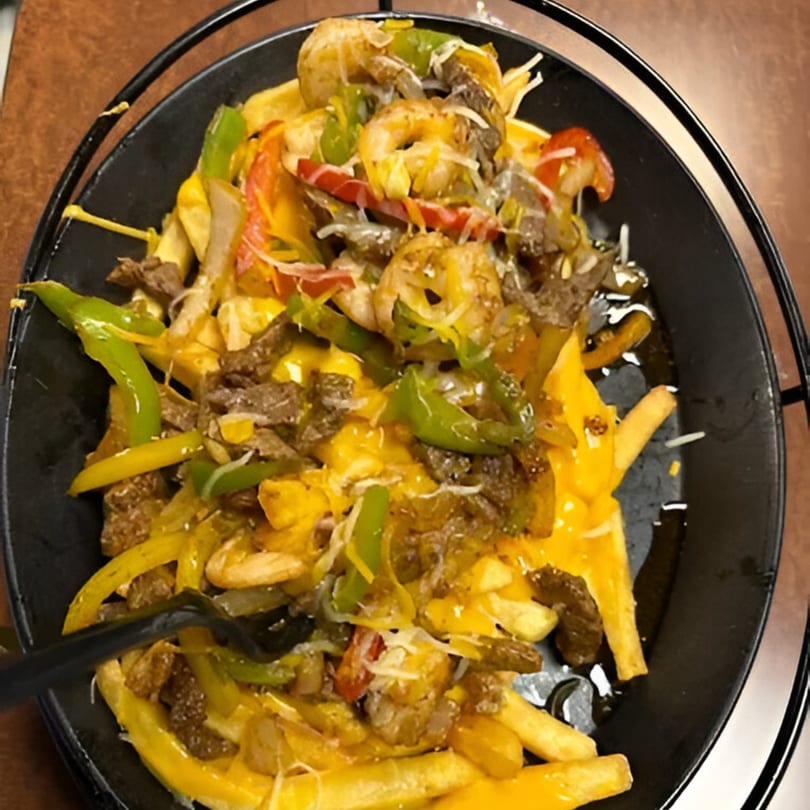 Both Worlds Twisted Potatoes & Company's loaded fries with steak, shrimp, cheese, and peppers.