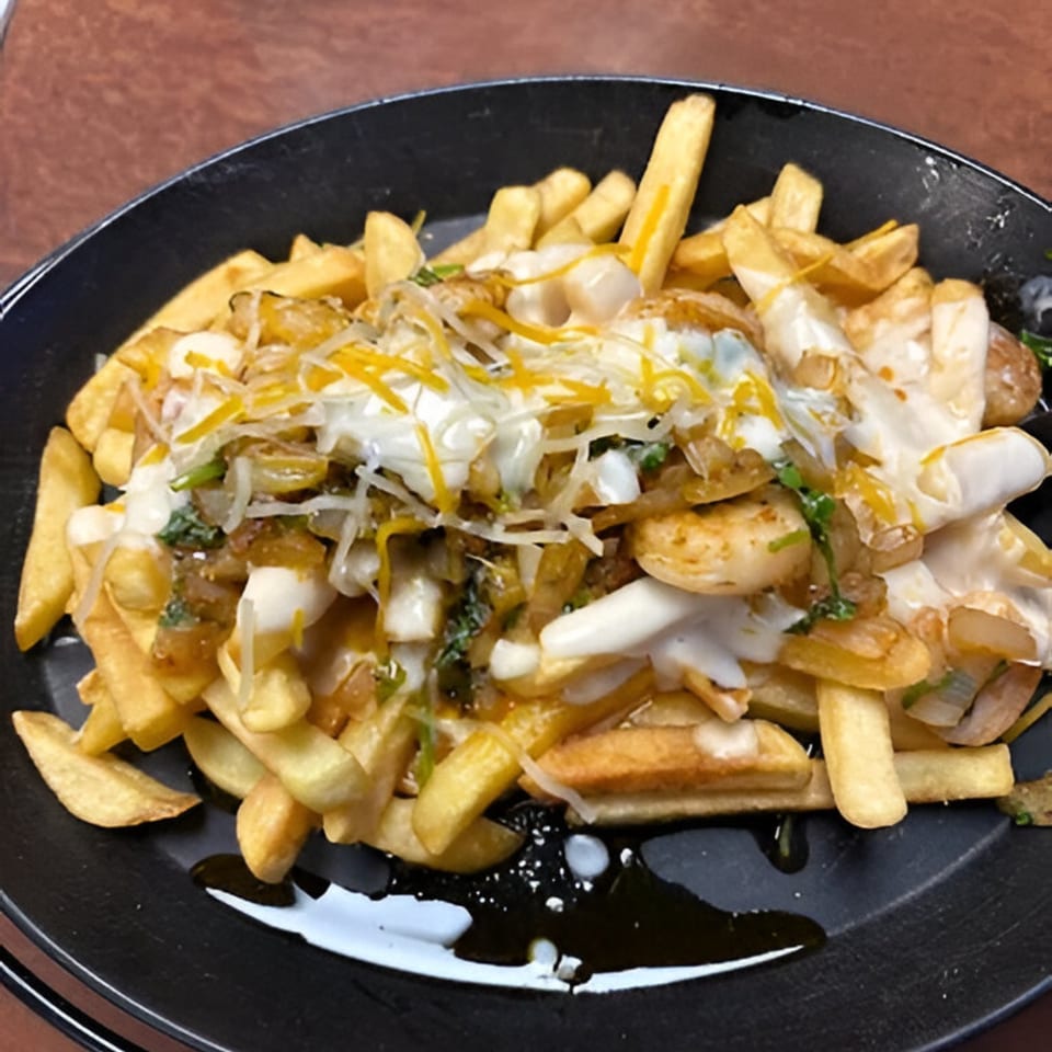 A black plate filled with golden french fries topped with cheese, sauce, and savory ingredients.